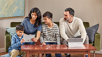 A family of four, seated on a couch together